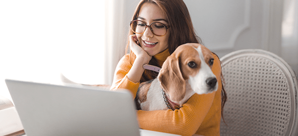 image of woman with her dog (a beagle),using a latop image