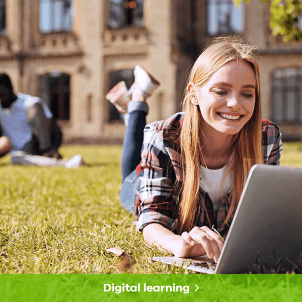 Digital learning - image of woman laying on the grass at a college/university campus withe a laptop. She is smiling.
